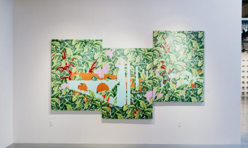 A three panel painting of green ferns with an abstract orange and white pattern superimposed on the leaves hangs on a white gallery wall