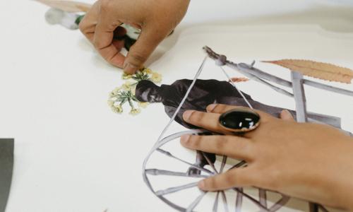 Close up image of Tya Anthony's hands working on a collage in her studio 