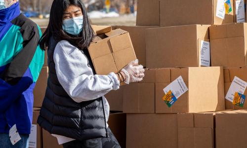 Image of a woman unloading boxes of donations